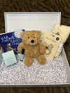 Teddy bear with gift card and card in a box on a textured surface