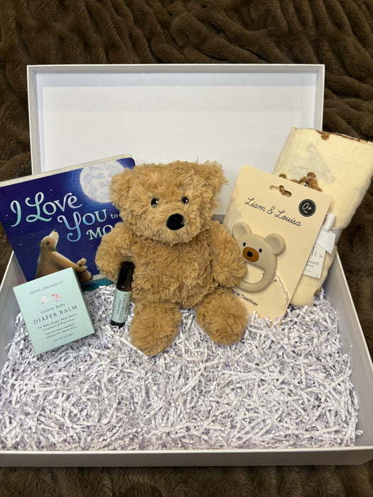 Teddy bear with gift card and card in a box on a textured surface